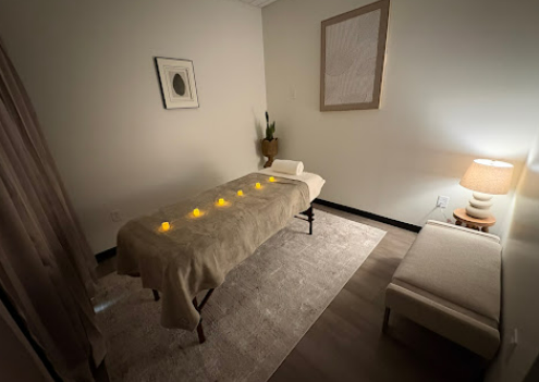 The Grounding Therapeutic Massage treatment room with a massage table and warm lighting